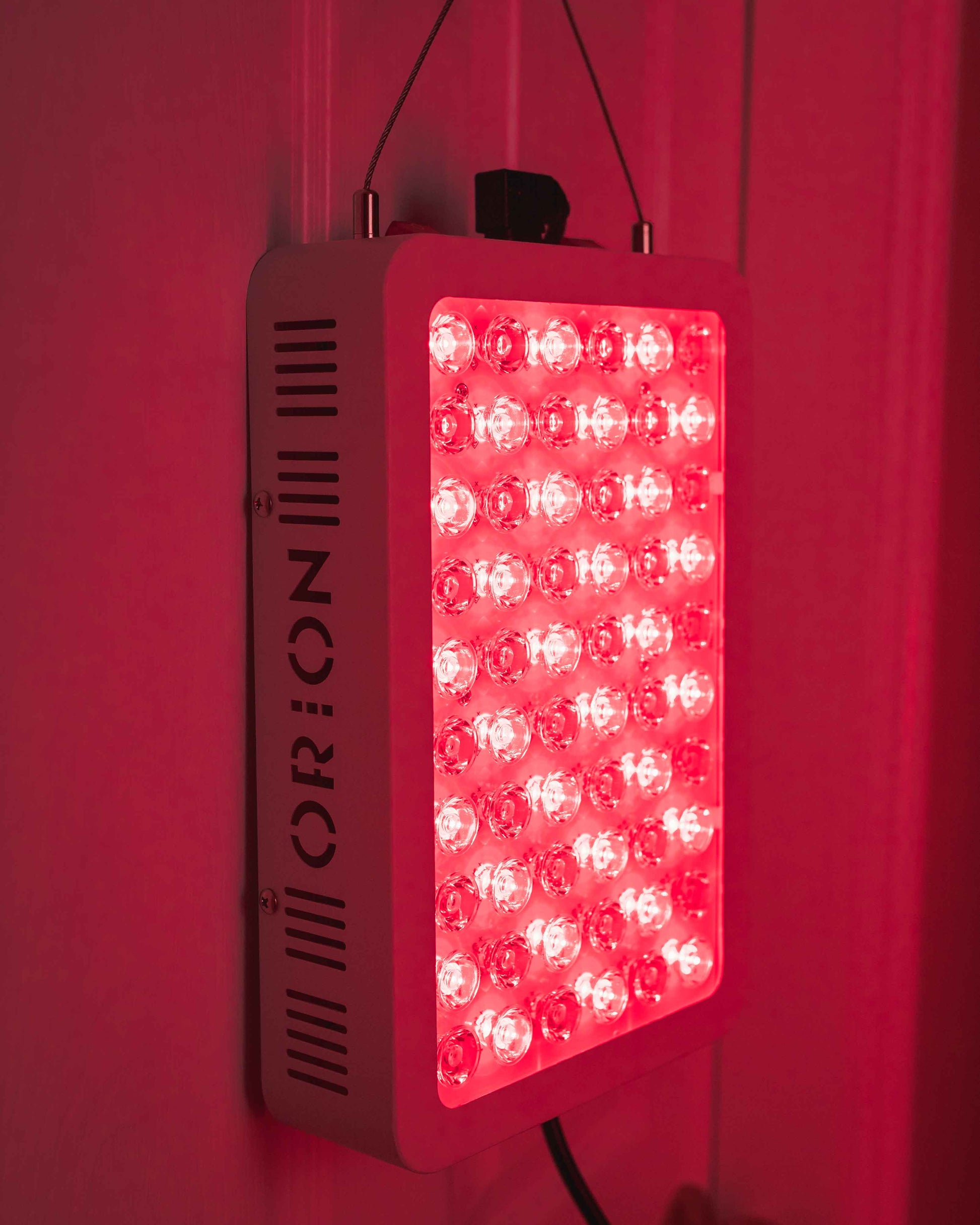 Orion 300 with the red and near-infrared lights turned on and hung up on the door. Orion Red Light Therapy. 