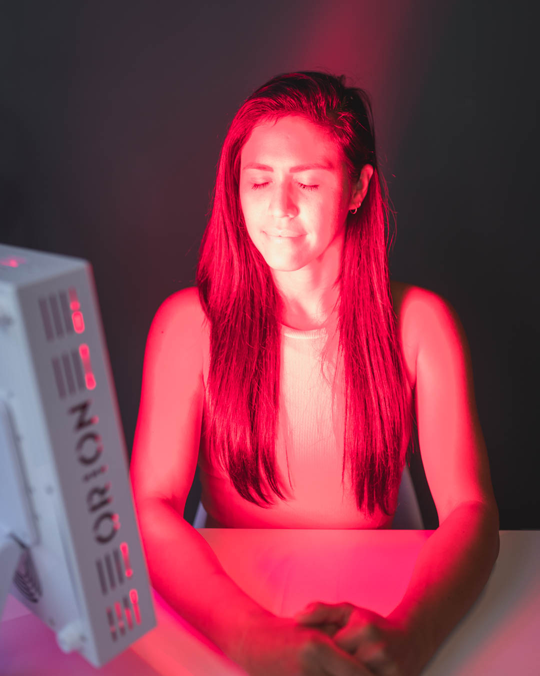 Orion Red Light Therapy - woman using the Orion Pro 300 for face